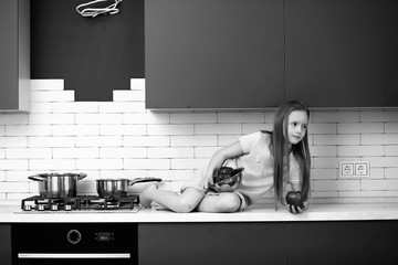 Little girl in the kitchen black and white