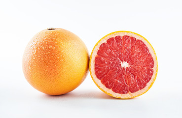 Fresh grapefruit and cut red flesh on white background