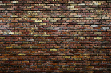 masonry concept of vintage aged brick wall of red and yellow color in urban darkness with copy space
