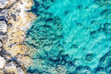 Aerial view of beautiful seashore in summer. Rocky beach and green islands seen from above.