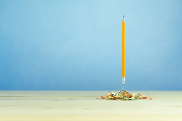 Ideas and Creativity with Pencil in the form of a rocket on table on blue background, copy space