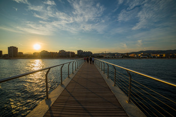 Obraz premium Pont de Petroli. Piękny zachód słońca widziany z małego mostu dla pieszych przy plaży w Barcelonie, Hiszpania.