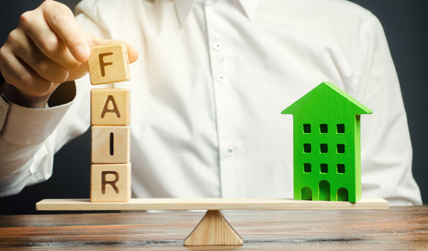 Wooden Blocks With The Word Fair And A Wooden House. Fair Value Of Real Estate And Housing. Property Valuation. Home Appraisal. Housing Evaluator. Legal Transparent Deal. Apartment Purchase / Sale.