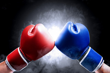 Hands of two men with blue and red boxing gloves