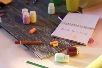  School supplies, frame, inscription in notebook on a wooden table, preparation for learning, education