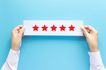 rating and feedback concept. customer holding paper with satisfied review by give five star for...