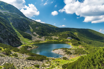 Naklejka na ściany i meble Panoramic view on mountain lake in front of mountain range