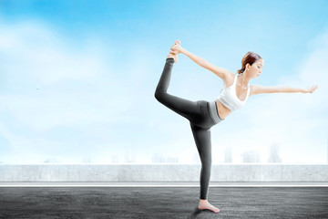 Fototapeta premium Asian healthy woman practicing yoga on the rooftop