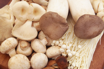 Raw mushrooms on wooden board close up