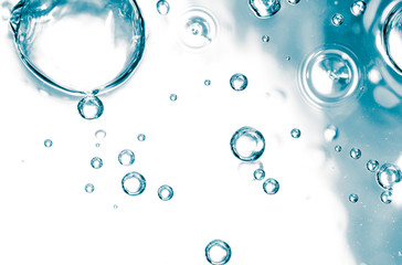 Bubbles of air on the smooth surface of blue water as an abstract background