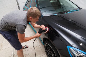 The polisher polishes the body of the vehicle with special wax to protect the car from minor scratches and damage, using a polishing eccentric machine to cover black fender after washing. Auto service