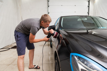 The polisher polishes the body of the vehicle with special wax to protect the car from minor scratches and damage, using a polishing eccentric machine to cover black fender after washing. Auto service