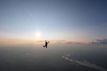 Skydiving. Sunset jump. A skydiver is falling near the sun.