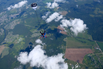 Skydiving. Tandem jump above  white clouds.