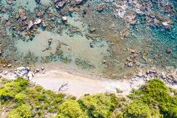 Aerial view of beautiful seashore in summer. Rocky beach and green islands seen from above.