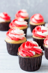 Delicious birthday cupcakes with red-white cream.