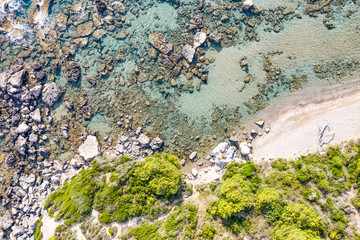 Aerial view of beautiful seashore in summer. Rocky beach and green islands seen from above.