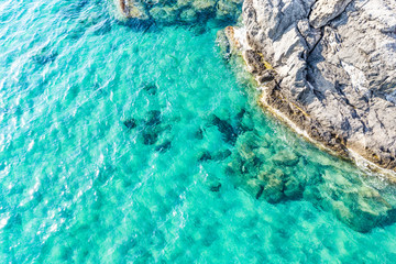 Aerial view of beautiful seashore in summer. Rocky beach and green islands seen from above.