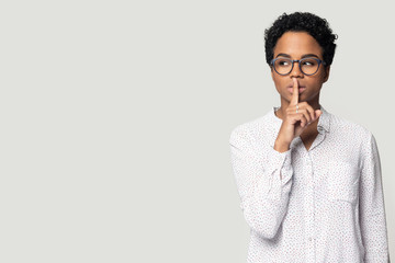 Black woman keep finger at lips aside blank copy space