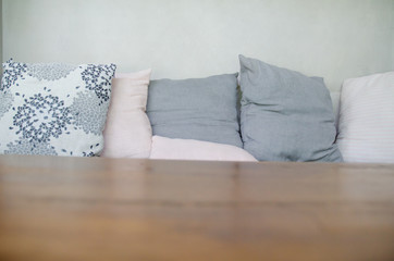 Gray pillow on the bed.On the couch there is a pillow on it.Do not focus on objects.