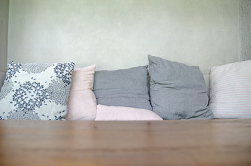 Gray pillow on the bed.On the couch there is a pillow on it.Do not focus on objects.