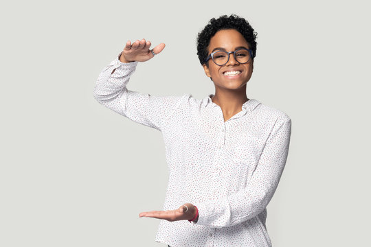 Smiling biracial girl show big size measurement with hands