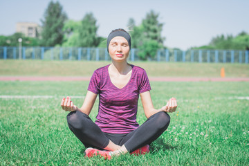 Fototapeta premium Young woman practicing morning meditation in nature at the park