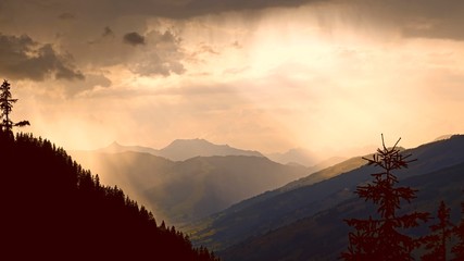 beautiful sunset and view in the mountains with rain, fog and sunbeams