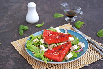 Summer salad of watermelon grilled, feta cheese and onions. Dressed with balsamic vinegar and olive oil. Selective focus. Healthy food.