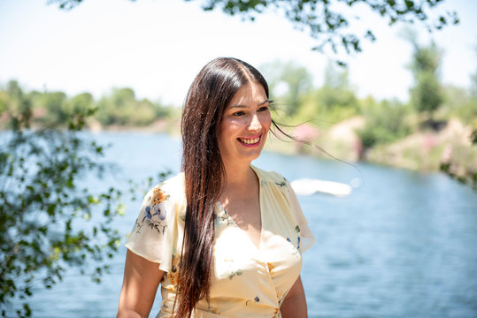 Pretty woman posing in the park by the lake