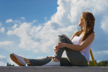 Girl wearing trousers and sneakers relax outdoor