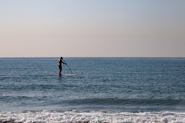 Naklejka premium Silhouette of a man doing paddle surf