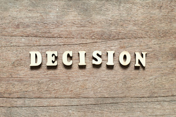 Naklejka premium Letter block in word decision on wood background