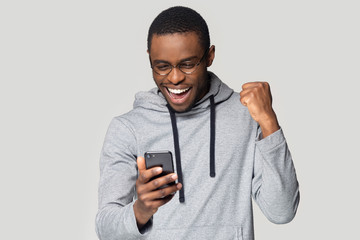 Excited black man feel overjoyed reading good news on cellphone
