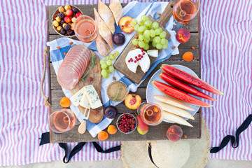 Picnic on the beach at sunset in the style of boho, food and drink conception