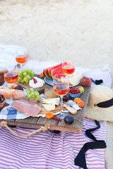 Naklejka na ściany i meble Picnic on the beach at sunset in the style of boho, food and drink conception