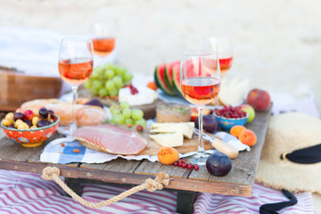 Fototapeta na wymiar Picnic on the beach at sunset in the style of boho, food and drink conception