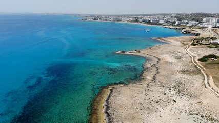 The rocky coast of Cyprus with azure water near Ayia Napa. Flying drone over the sea