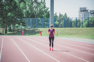 Fototapeta premium female in sportswear jogging along bridge border while training on stadium outdoors