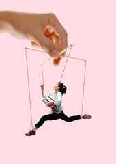 Woman like a puppet in somebodies hands on coral background. Concept of unfair manipulation,...