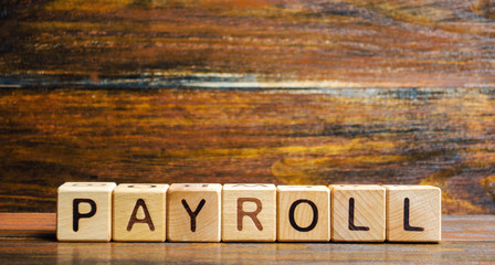 Wooden blocks with the word Payroll. Payroll is the sum total of all compensation a business must pay to its employees for a set period of time or on a given date. Business and Finance. Taxes.
