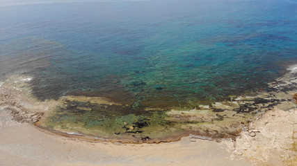 The rocky coast of Cyprus with azure water near Ayia Napa. Flying drone over the sea
