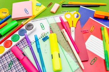 Back to school concept. School education supplies on bright green background