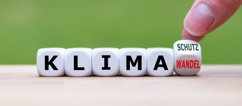 Symbol f&uuml;r mehr Klimaschutz: Hand dreht einen W&uuml;rfel und &auml;nder das Wort "Klimawandel" in "Klimaschutz".