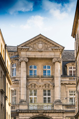 Fototapeta na wymiar Historical building with columns, sculpture and white windows. Metz, France