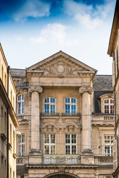 Historical building with columns, sculpture and white windows. Metz, France
