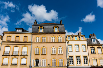 Fototapeta na wymiar yellow apartments with white shutters on square Place Saint Louis. Metz, France