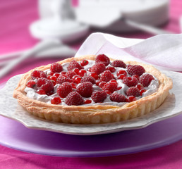 Tarta de frambuesa y grosellas sobre plato morado. Raspberry and currant tart on a purple plate.