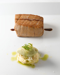 Atún  a la plancha con puré de verduras sobre fondo blanco. Grilled tuna with vegetable puree on white background.