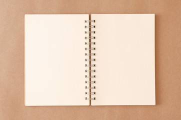 An empty notebook that has been left open on an old brown background.